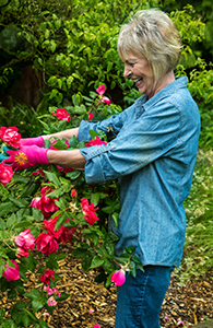 Woman shows off her tooth implant in Seattle while gardening.