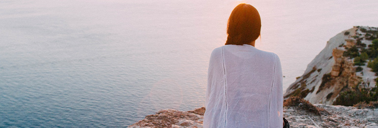 Woman relaxing by the water to demonstrate peace of mind from sedation dentistry in Seattle